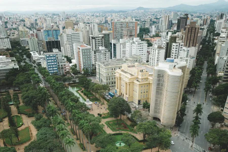 Avenida arborizada de Belo Horizonte vista do alto, com prédios e praça